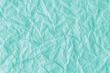 Recycled crumpled turquoise paper texture background. Wrinkled and creased abstract backdrop, wallpaper with copy space, top view.
