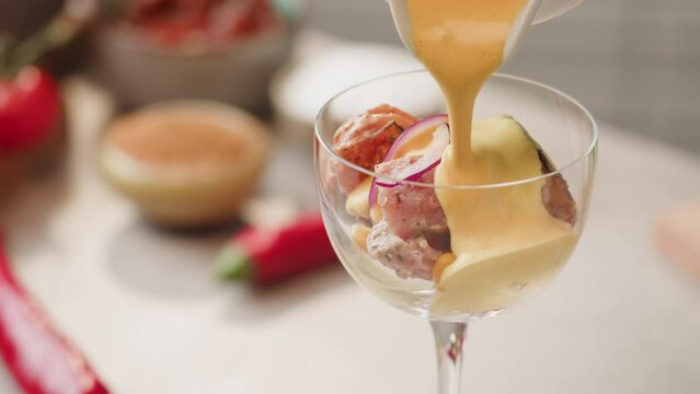 Chef cooking ceviche, leche de Tigre, traditional peruvian food, ceviche on table close-up. Traditional Peruvian or mexican cuisine with fresh seafood prawns in wine glass. 