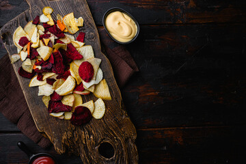 Root Vegetable Crisps, on black wooden table background, top view flat lay, with copy space for text
