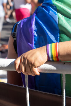 Gay Boyfriend Hugs Partner at Pride Month to celebrate love. LGBTQ, Rainbow flag, Diversity. Vertical.