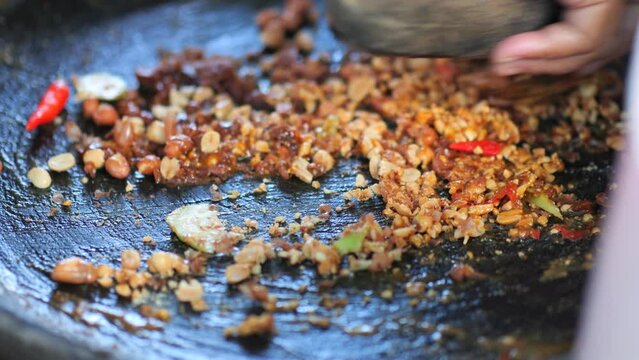 Preparing rujak petis.Rujak petis is traditional food from Java made from steamed mix vegetables, black sauce made from fried garlic, chillies, petis (black fermented shrimp paste) and ground peanuts