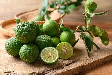 Kaffir lime and lime fruit on wooden background, Organic ingredients in Thai cuisne, beauty and cosmetics