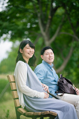 公園で休憩する妊婦と夫