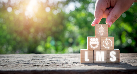 LMS, Learning Management System concept, Person hand holding wooden block with Learning Management...