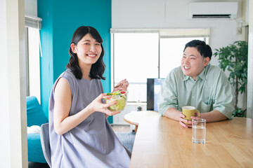 昼食を食べる妊婦と彼女を見守る夫