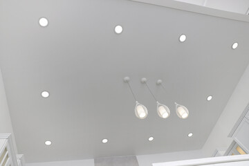 Ceiling with modern lamps in stylish room, low angle view