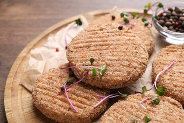Tasty vegan cutlets with breadcrumbs on wooden board, closeup