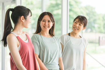 スポーツジムでスポーツウェアを着て話す女性達
