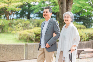 公園を歩くシニア・高齢者夫婦（散歩・リフレッシュ・ウォーキング）
