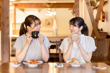カフェ・レストラン・飲食店でランチをしながらおしゃべりする若いアジア人女性

