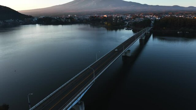 Drone shot following a car on the Kawaguchiko Bridge, with Mount Fuji Background