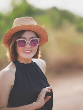 beautiful asian woman toothy smiling with happiness standing outdoor  and raising right hand