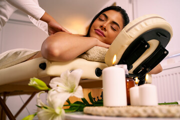 Obraz na płótnie Canvas Amazingly beautiful dark hair girl having a massage, enjoying with eyes closed, spa treatment 