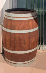 An old oak barrel stands at the entrance to a beer restaurant, shop, as an element of vintage design, vertical photo