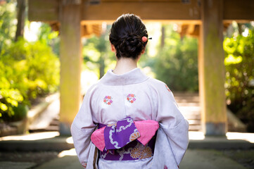 Fototapeta premium 門前に立つ着物を着た美しい日本人女性