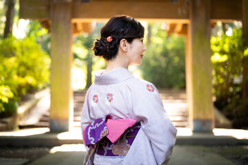 Fototapeta premium 門前に立つ着物を着た美しい日本人女性