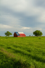 Barn in green grass field © Daniel