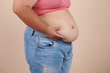 she wants to lose weight concept of abdominal fat surgery., the girl takes extra fat on sides of her stomach with her hand. isolate on white background, Type with increased fat deposition and fullness
