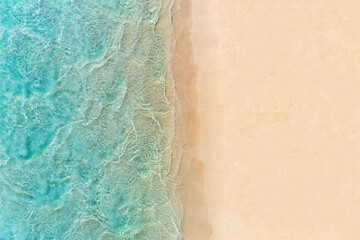 Aerial top down view of beach and turquoise water. Ocean waves on the beach as a background....