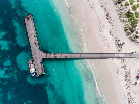 Aerial view of sandy beach with waves and fishing jetty in Lancelin, Western Australia. Sunny day in summer with tropical blue water. Top view. Coastal, Seascape. Aerial view beautiful tropical