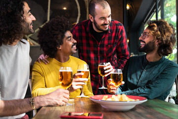 Group of happy male friends having beer in a pub.