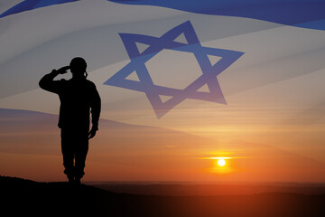Silhouette of soldier saluting against the sunrise in the desert and Israel flag.