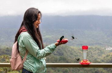 mujer joven latina observando a colibries en mindo ecuador