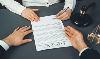 Lawyer signing contract, professional lawyer in law firm library drafting legal document or...