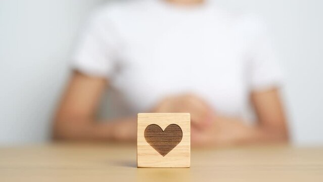 Hand holding heart block for health care, love, organ donation, charity, happy family, wellbeing and insurance concepts. world heart day, health day and mental health day