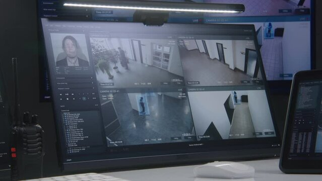 Video footage of surveillance CCTV cameras with AI face scanning system displayed on computer monitors and tablet. Big digital screen with big data on background. Security monitoring center. Timelapse
