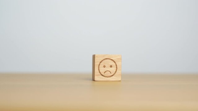 Hand choosing unhappy angry face from Emotion block. customer review, bad experience, negative feedback, satisfaction, survey, rating service, assessment, mood, world mental health day concepts