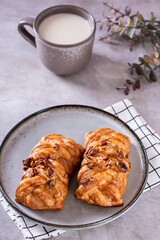 Swedish fika time with fresh cinnamon buns and a cup of latte on the table vertical view