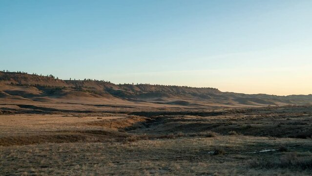 Time lapse sunrise over prairie valley and creek bed