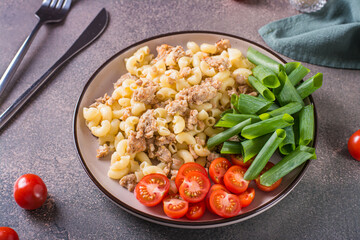 Naval pasta with cherry tomatoes and chives on a plate on the table