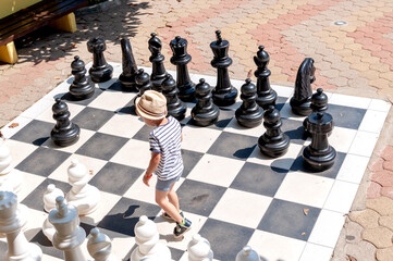 the boy is playing big chess