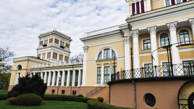 An old yellow building against the background of the sky with clouds. Rumyantsev-Paskevich Palace in a city park in Gomel, Belarus. Panorama from left to right