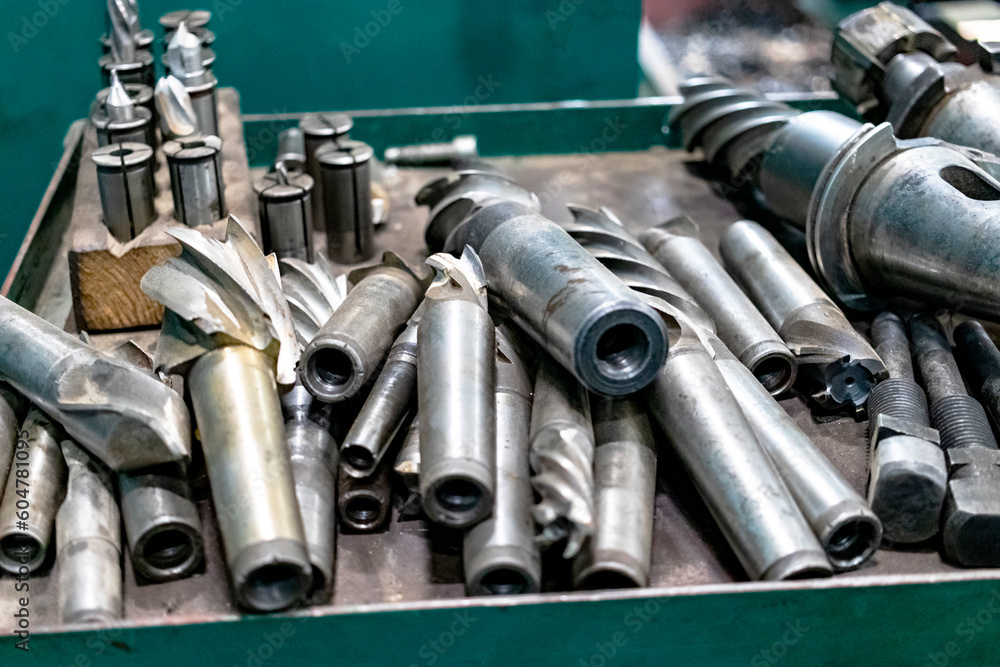 Poster a set of milling cutters on a rack near a lathe. metalworking cutting mills for cnc machines. indust