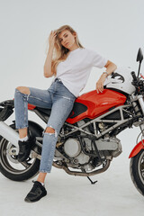 Naklejka na ściany i meble Studio shot of isolated in white background blond woman and custom modern motorcycle.