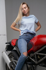 Fototapeta na wymiar Shot of dressed in casual clothing woman motorcyclist and her powerful motorbike.