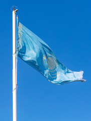 Flag of the Republic of Kazakhstan waving in the wind against the blue sky