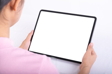 Women hand useing tablet on table, tablet have white screen, rear. view from back to front of women