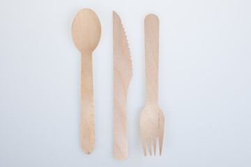 wooden fork spoon and knife made from recycled brown wood on white Background