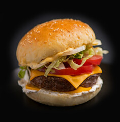 Big tasty burger with beef cutlet on a black background