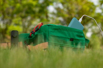 Bag with a smartphone is charged using a power bank. Portable charger in nature and travel.