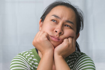 Bored woman sitting at desk at home. Asian woman who is bored, tired and needs a relax day.