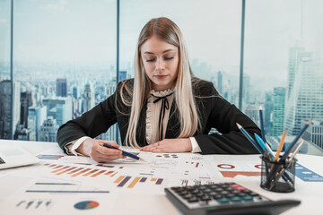 Beautiful caucasian business woman wear suit work with financial graph nad chart