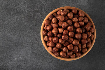 View of a bowl full of hazelnuts on a black background 