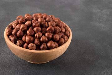 View of a bowl full of hazelnuts on a black background
