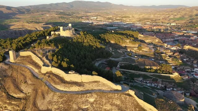 Picturesque aerial view of remains of ancient moorish Ayub Castle with fortification walls on top of green hill above Spanish city of Calatayud in province of Zaragoza on sunny spring day. High