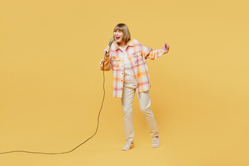 Full body singer happy fun elderly blonde woman 50s years old she wears casual clothes sing song in...